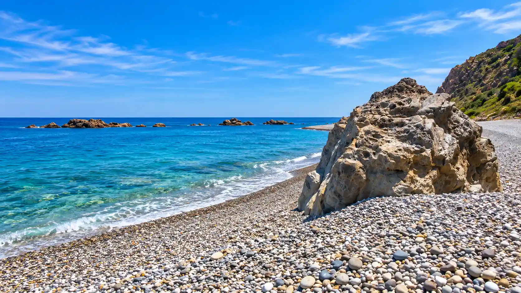 Plage La Cave à Damous dans la wilaya de Tipaza, galets et mer bleue au pied des reliefs